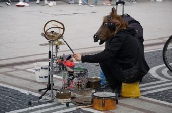 man in a horse costume plays drums